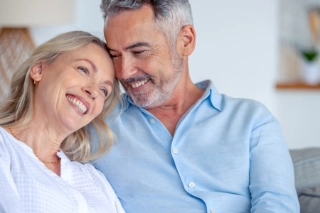 Frau lehnt sich an Ihren Mann an und beide lächeln